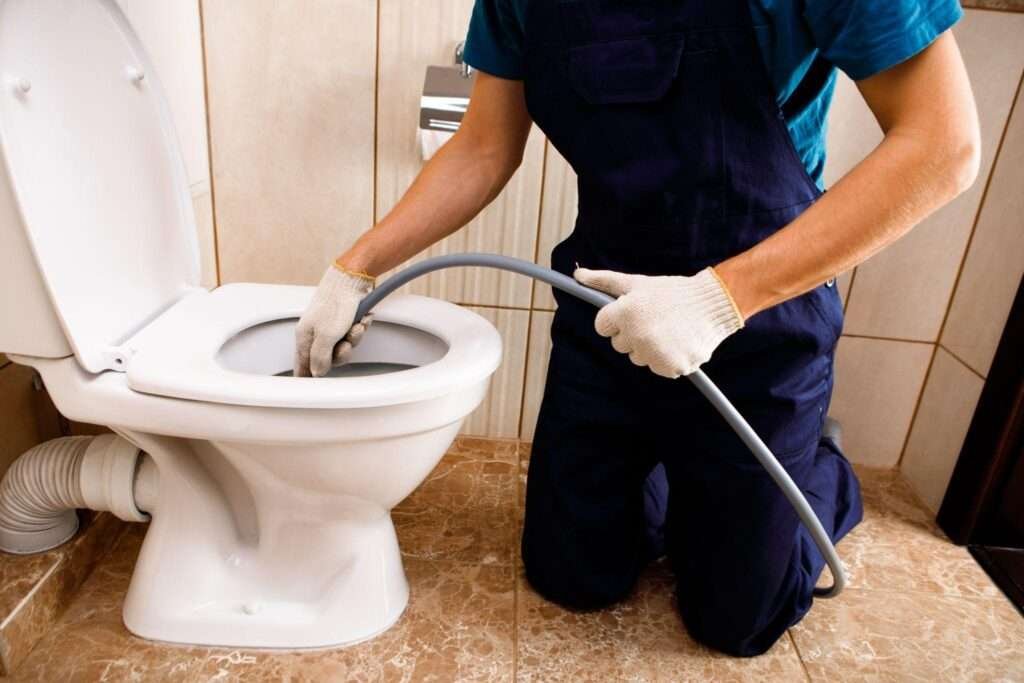 plumber unclogging blocked toilet with hydro jetting 1024x683 1