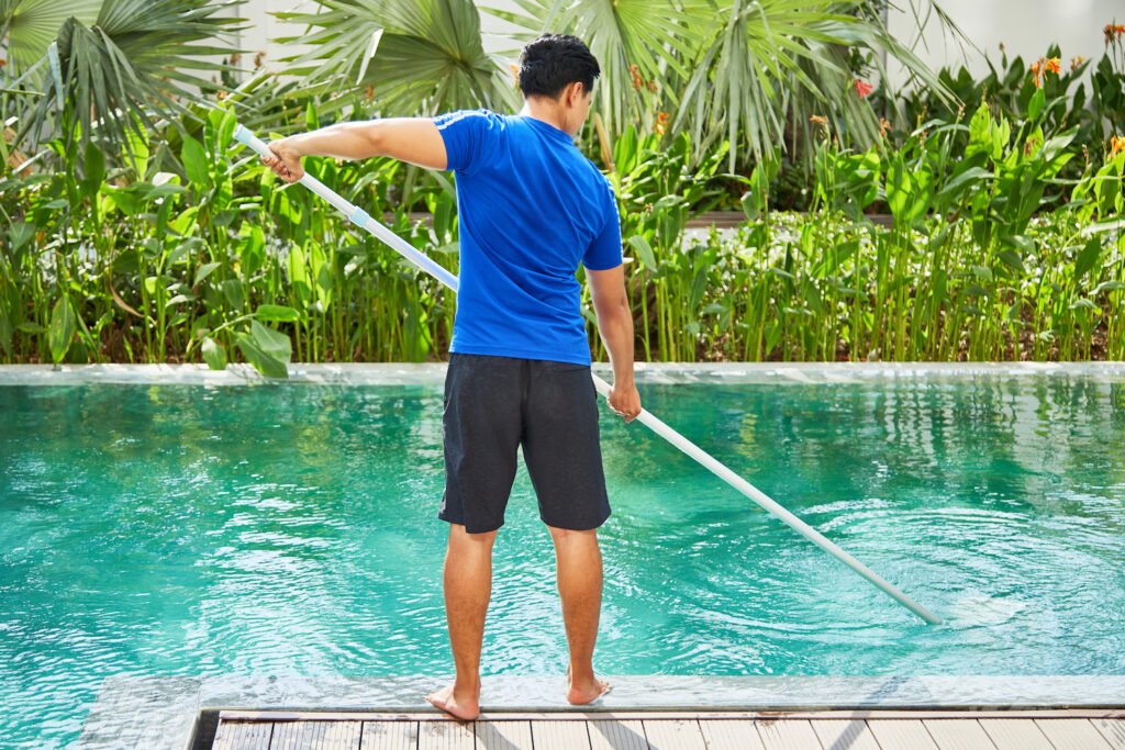 Young man cleaning pool