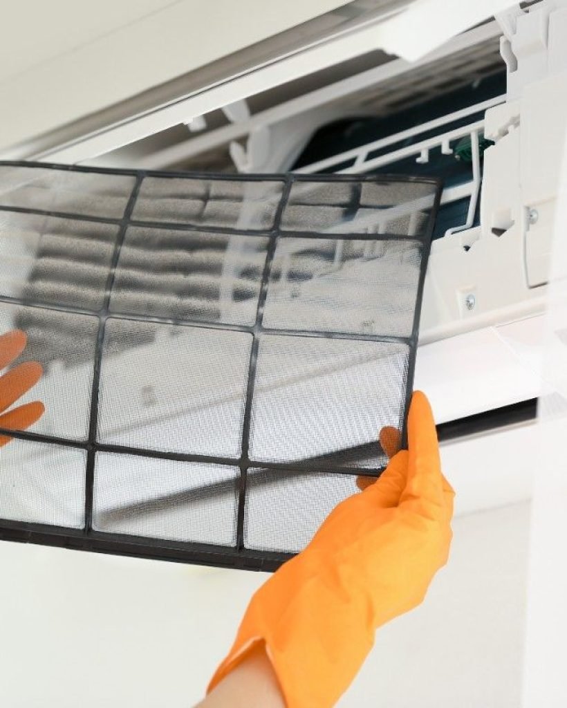 young-woman-cleaning-conditioner-from-dust-indoors